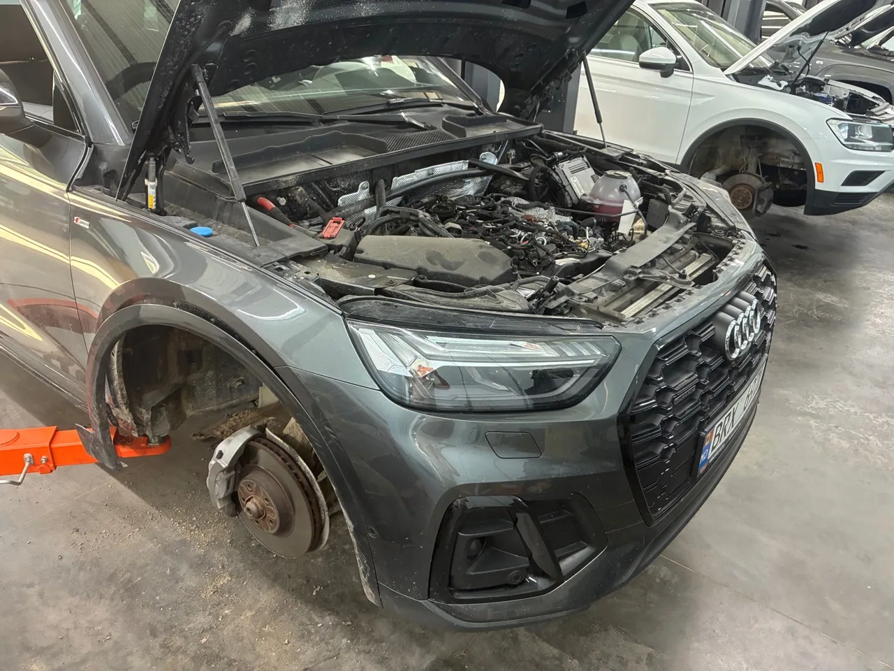 Audi Q5 с открытым капотом и снятыми колёсами в цехе BRAVO MOTORS